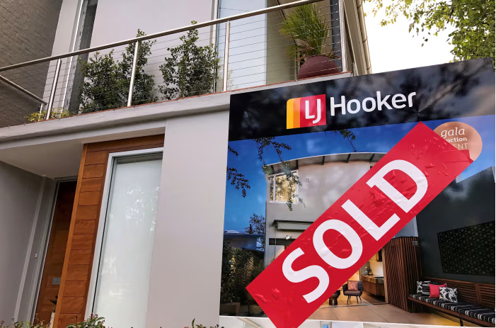 Modern Australian home with a sold sign reflecting impact of RBA rate cut on property market